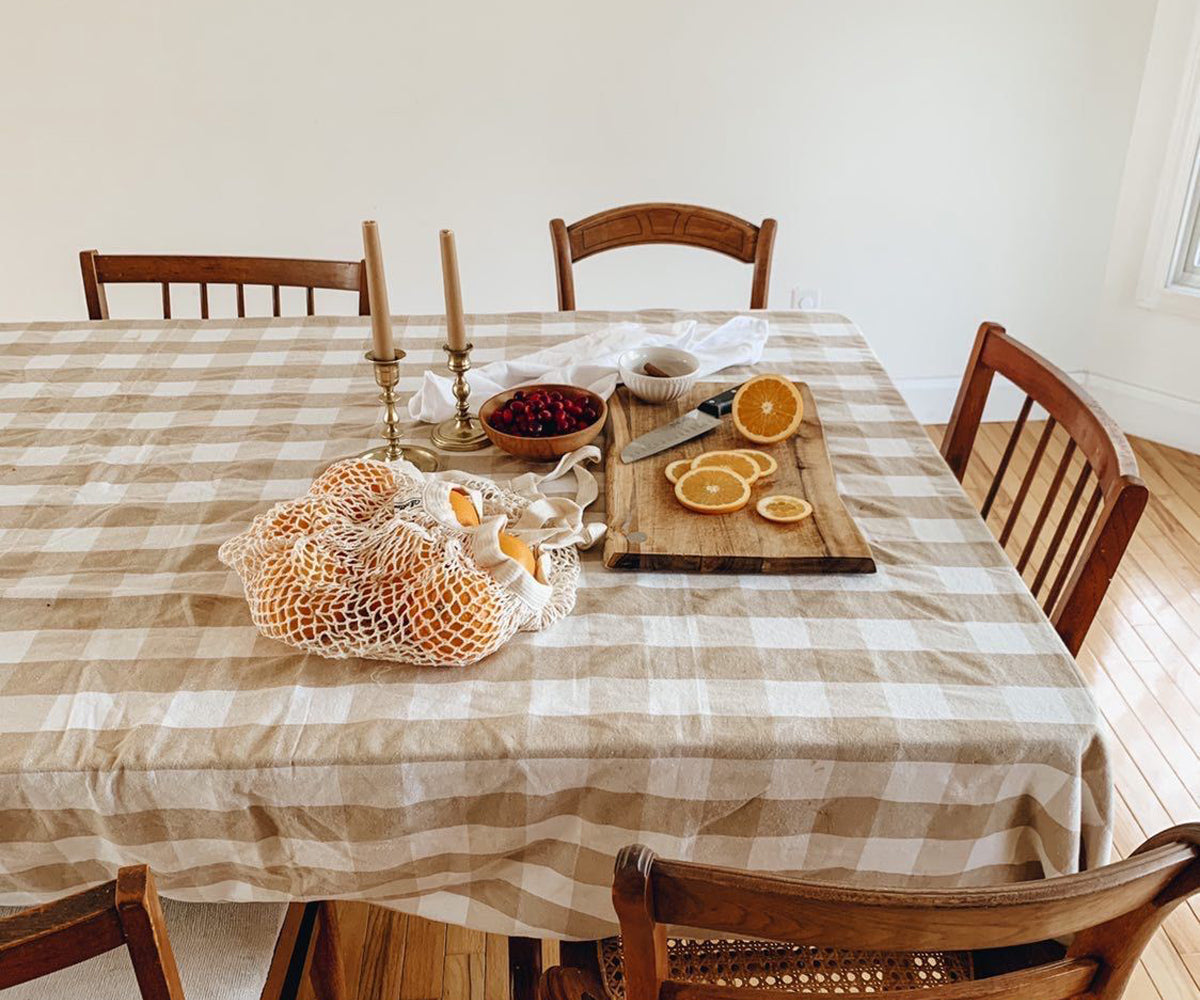 Neutral outdoor tablescape with white linens(BEIGE TABLECLOTHS AND CLOTH NAPKINS BY FOLDING NAPKINS INTO SHAPES), candles, and greenery set for summer dining. Neutral outdoor tablescape with white linens(BEIGE TABLECLOTHS AND CLOTH NAPKINS BY FOLDING NAPKINS INTO SHAPES), candles, and greenery set for summer dining.