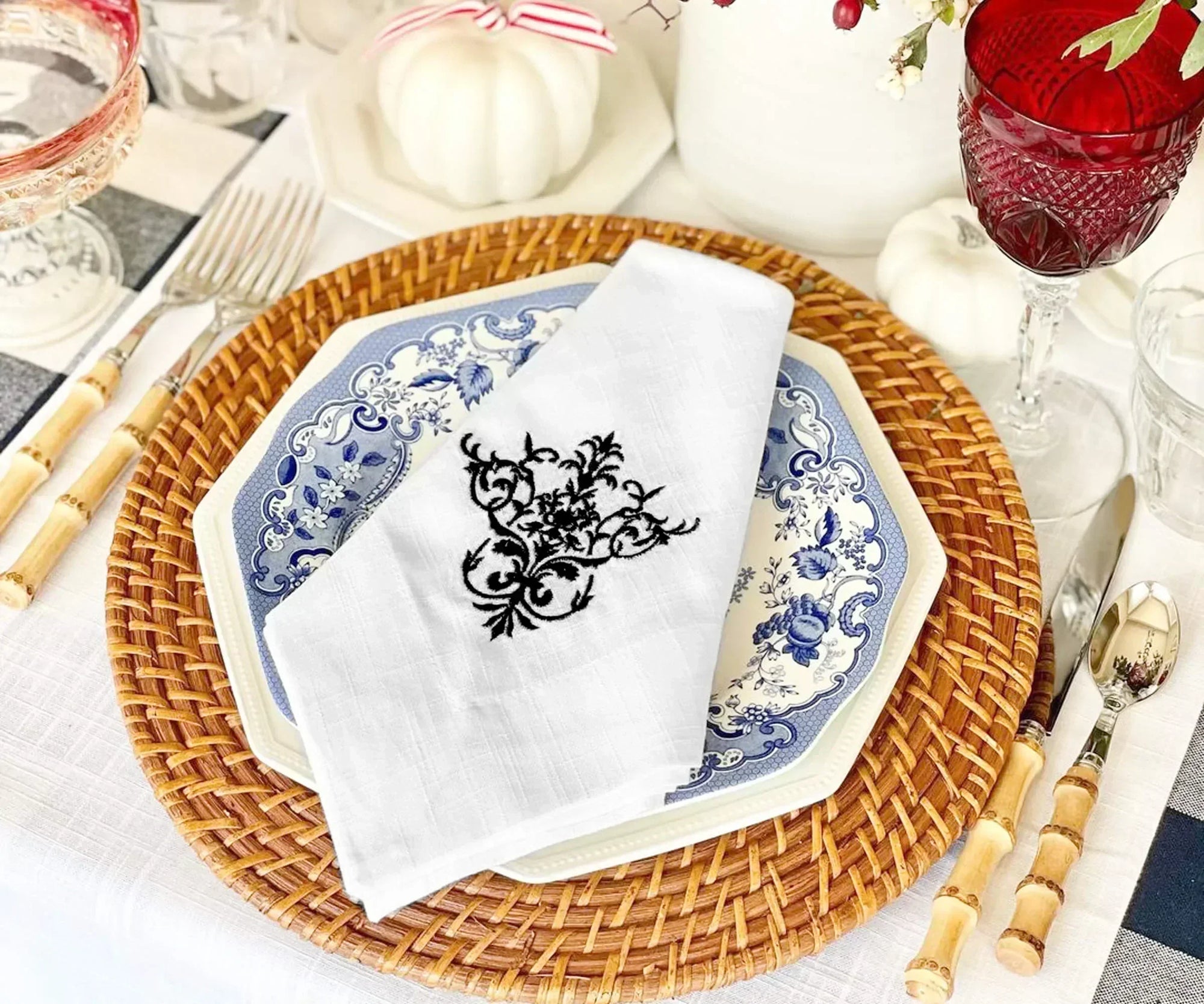 Personalized linen napkin with embroidered monogram on a dinner table Personalized linen napkin with embroidered monogram on a dinner table