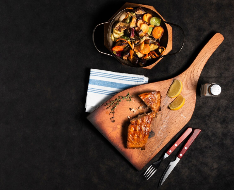 A variety of grilled dishes on a cotton tablecloth, including salmon, ribs, and hamburgers A variety of grilled dishes on a cotton tablecloth, including salmon, ribs, and hamburgers