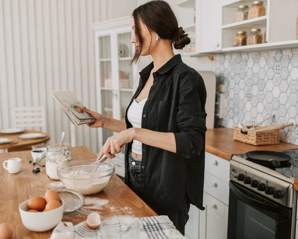 A woman in a kitchen mixing ingredients with a whisk for making a winter recipe A woman in a kitchen mixing ingredients with a whisk for making a winter recipe