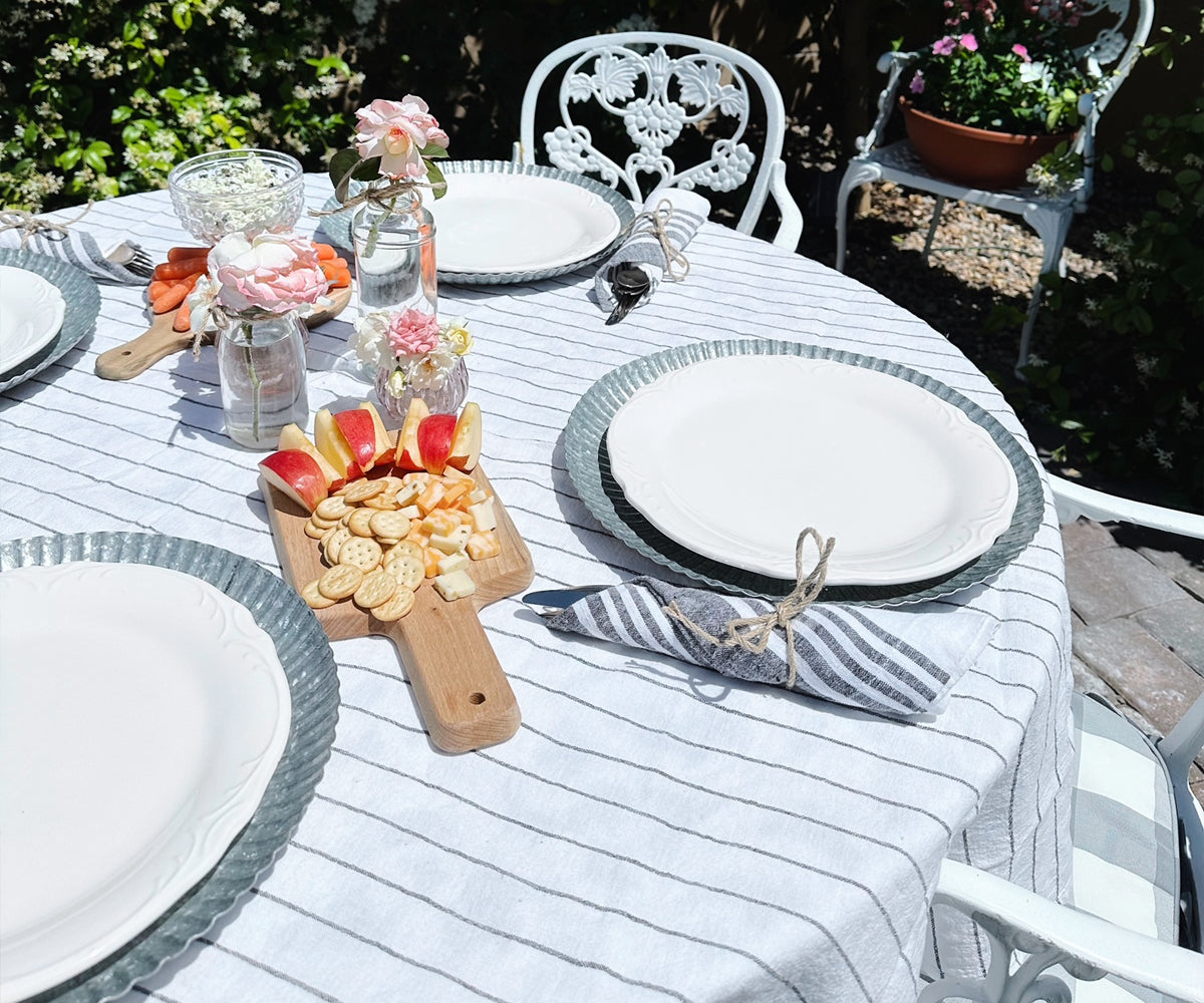 Minimalist dining room with a round linen tablecloth, modern chairs, and a simple centerpiece. Minimalist dining room with a round linen tablecloth, modern chairs, and a simple centerpiece.