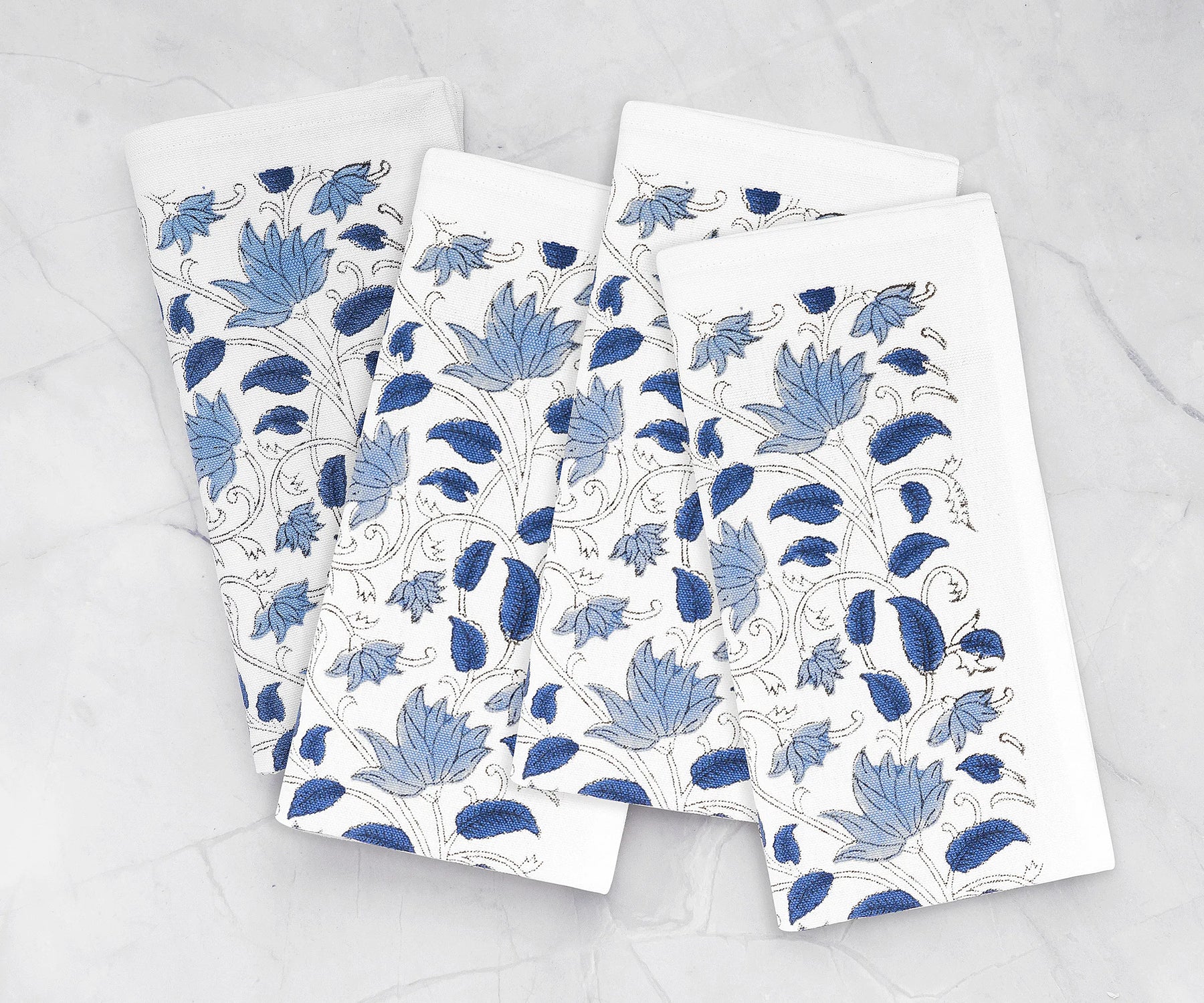 Set of 4 blue floral cotton napkins with hand block print on dining table Set of 4 blue floral cotton napkins with hand block print on dining table
