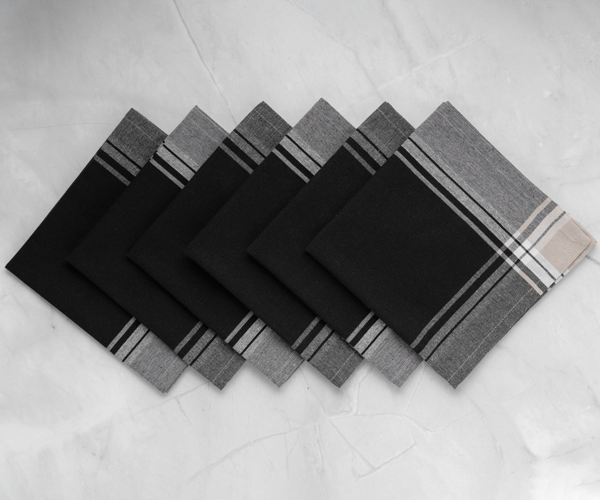 Six black cotton napkins displayed on a marble countertop Six black cotton napkins displayed on a marble countertop