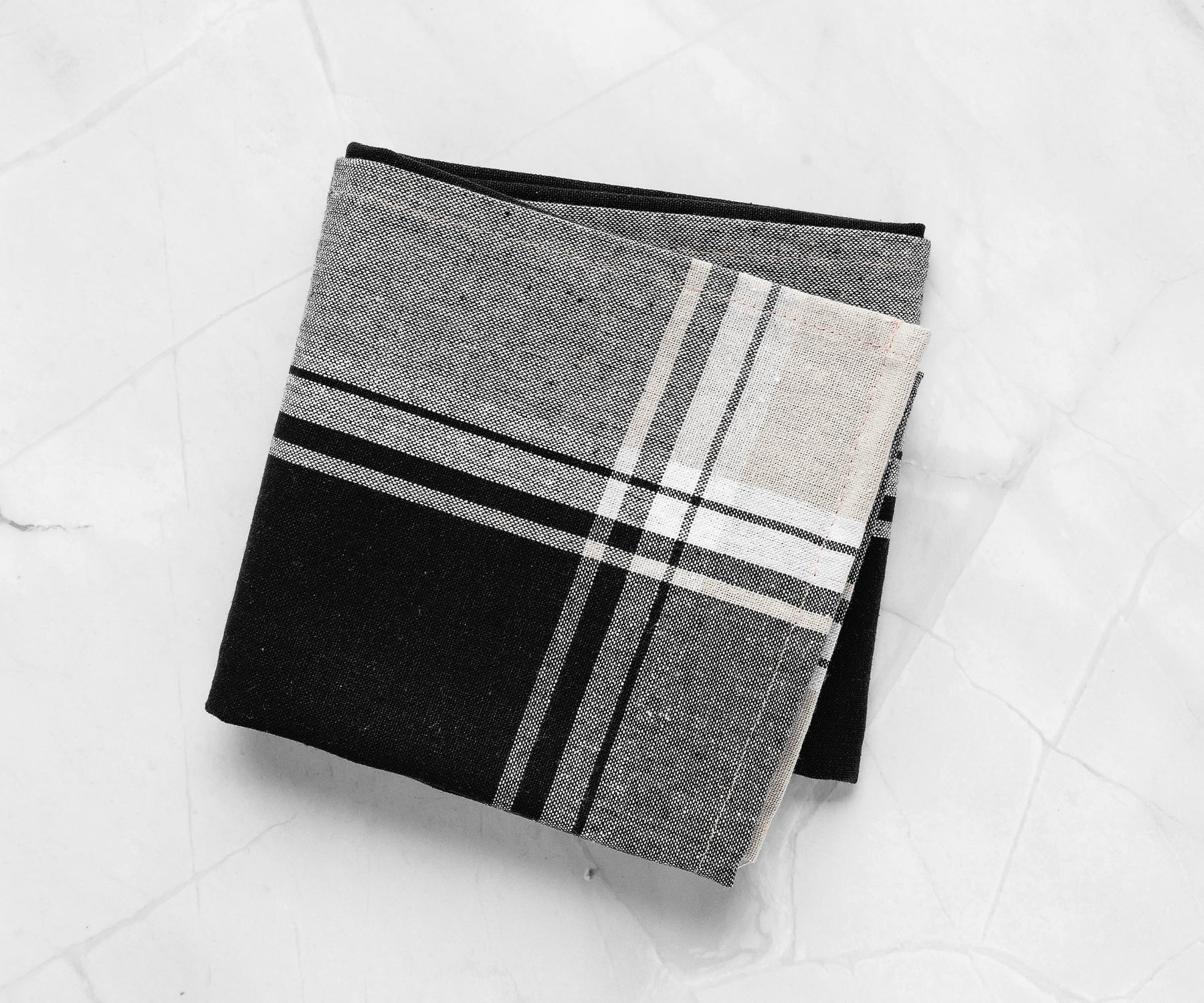 "A vibrant black and white kitchen towel spread across a dining table.