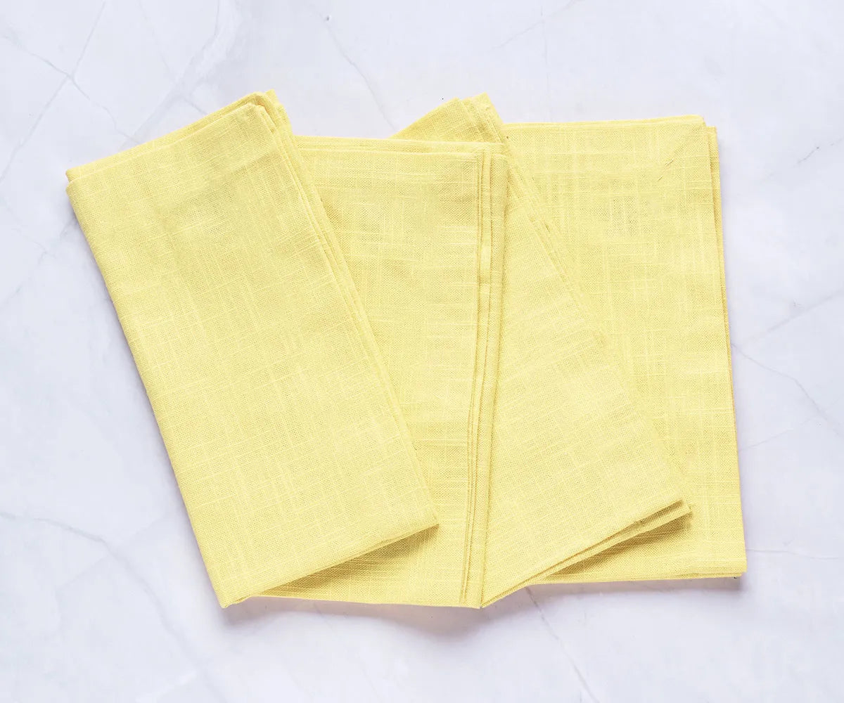 Butter yellow cotton napkins neatly folded in a stack – 100% cotton reusable cloth napkins, perfect for summer dining. Butter yellow cotton napkins neatly folded in a stack – 100% cotton reusable cloth napkins, perfect for summer dining.
