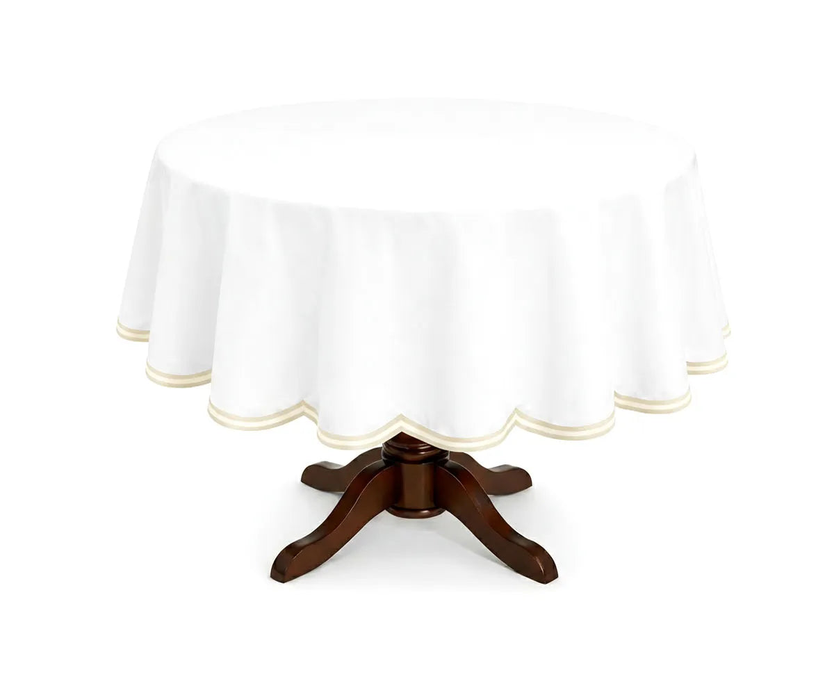 Ivory round cotton tablecloth accented with a white double scalloped edge, crafted from smooth cotton for an elegant table presentation. Perfect for weddings, special occasions, and everyday dining on round tables. Ivory round cotton tablecloth accented with a white double scalloped edge, crafted from smooth cotton for an elegant table presentation. Perfect for weddings, special occasions, and everyday dining on round tables.
