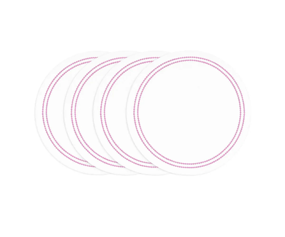 Pink and white round cotton placemats with embroidered pearl detail on dining table Pink and white round cotton placemats with embroidered pearl detail on dining table