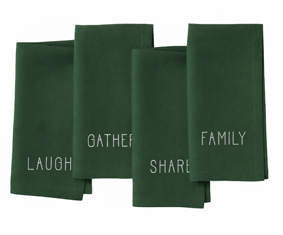 Dark green embroidered cotton napkin with white stitched “Laugh, Family, Share, Gather” design — timeless holiday table accent. Dark green embroidered cotton napkin with white stitched “Laugh, Family, Share, Gather” design — timeless holiday table accent.