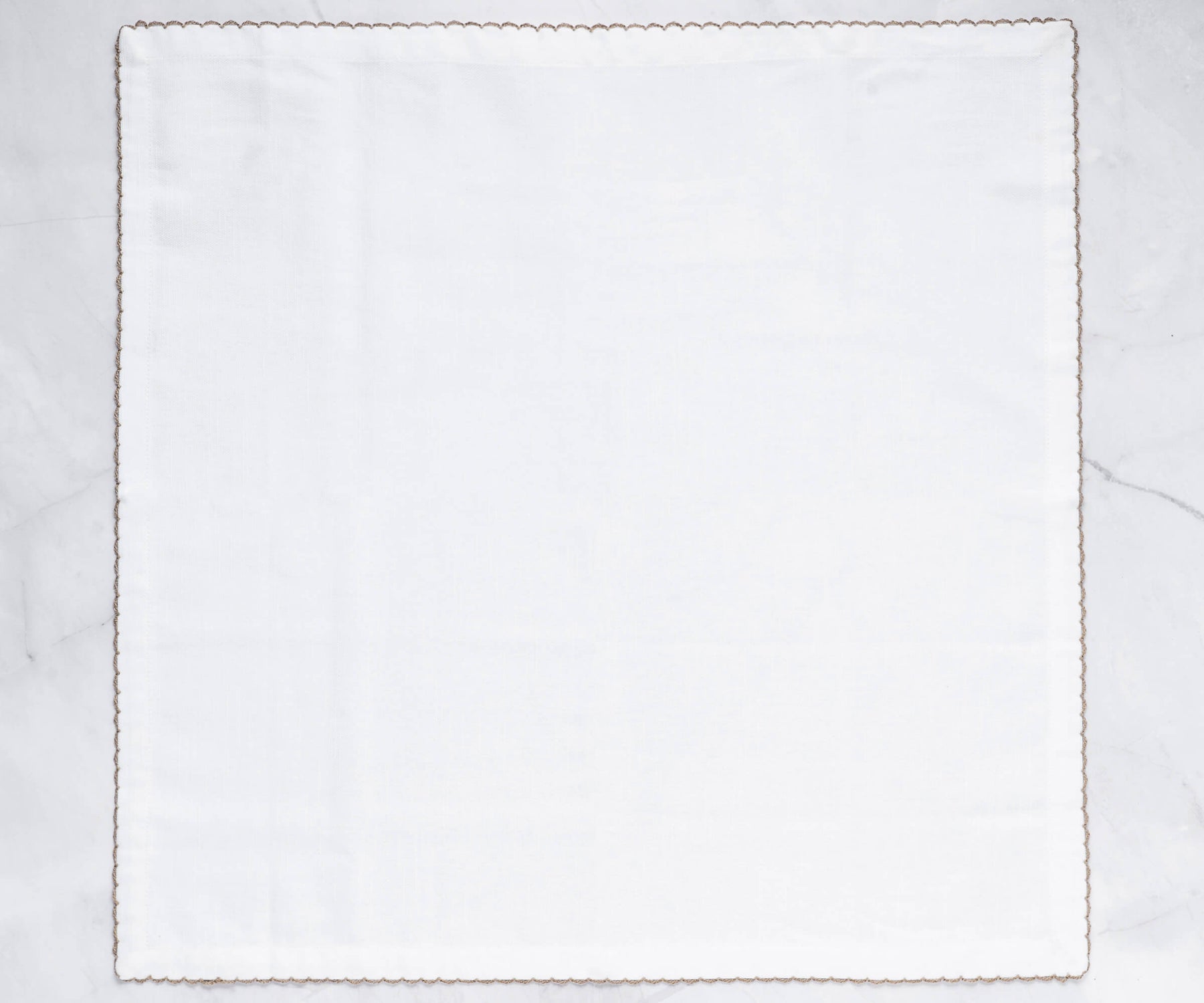 Single white napkin with gold shell embroidery and elegant border Single white napkin with gold shell embroidery and elegant border