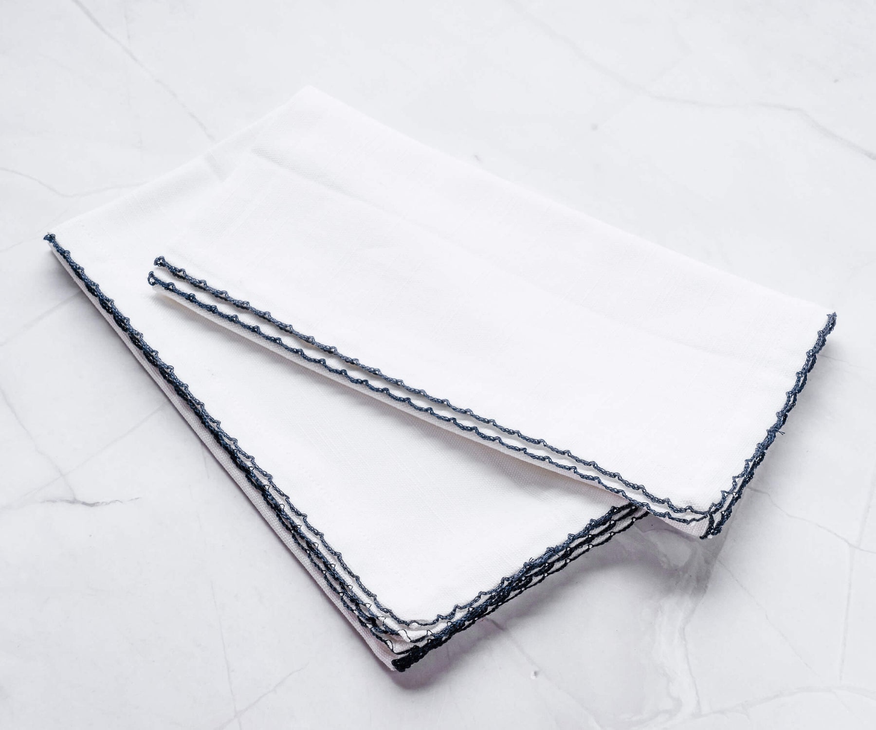 Pair of shell edge wedding napkins accented with blue trim Pair of shell edge wedding napkins accented with blue trim