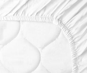 Detailed view of a mattress covered with a cotton fitted sheet