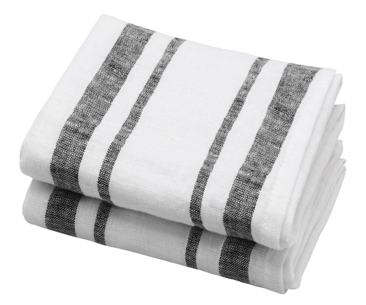 A black linen kitchen towel with striped patterns laid out next to a wooden plate on a beige background. A black linen kitchen towel with striped patterns laid out next to a wooden plate on a beige background.