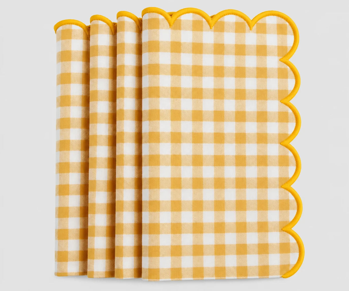 A stack of Yellow and white gingham check paper napkins with scalloped edges, shown on a clean white background. A stack of Yellow and white gingham check paper napkins with scalloped edges, shown on a clean white background.