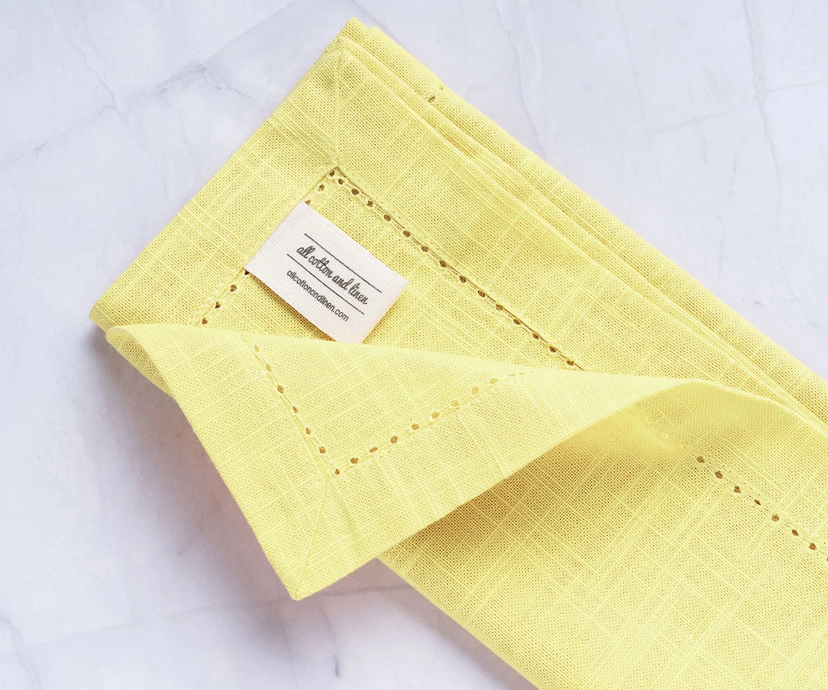 Elegant yellow fabric napkins paired with round cotton tablecloth Elegant yellow fabric napkins paired with round cotton tablecloth