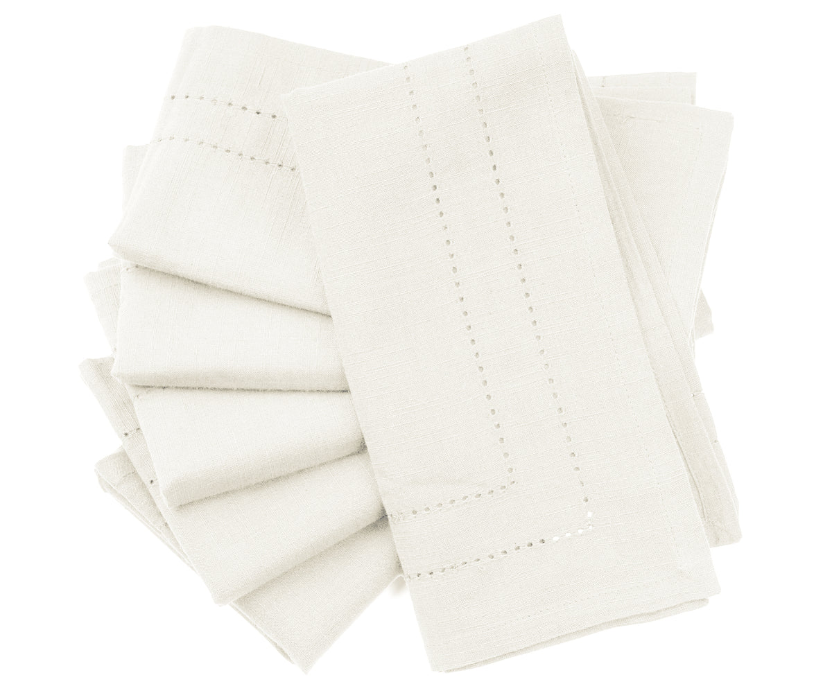 Elegant hemstitch dinner napkins in a calming light ivory color for a polished table setting Elegant hemstitch dinner napkins in a calming light ivory color for a polished table setting