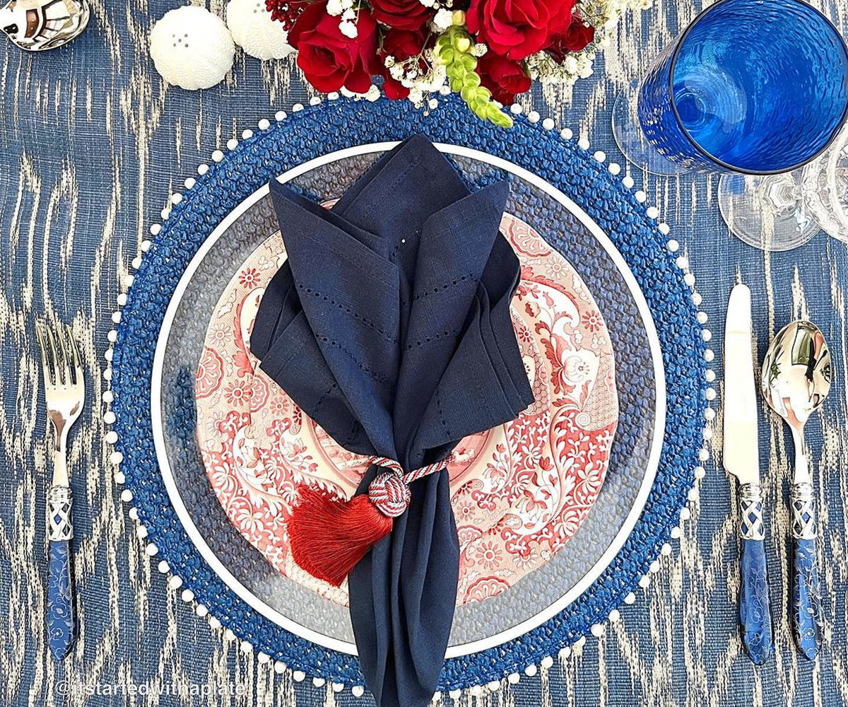 Vibrant table decor with Cloth Dinner Napkins on a blue and red patterned tablecloth Vibrant table decor with Cloth Dinner Napkins on a blue and red patterned tablecloth