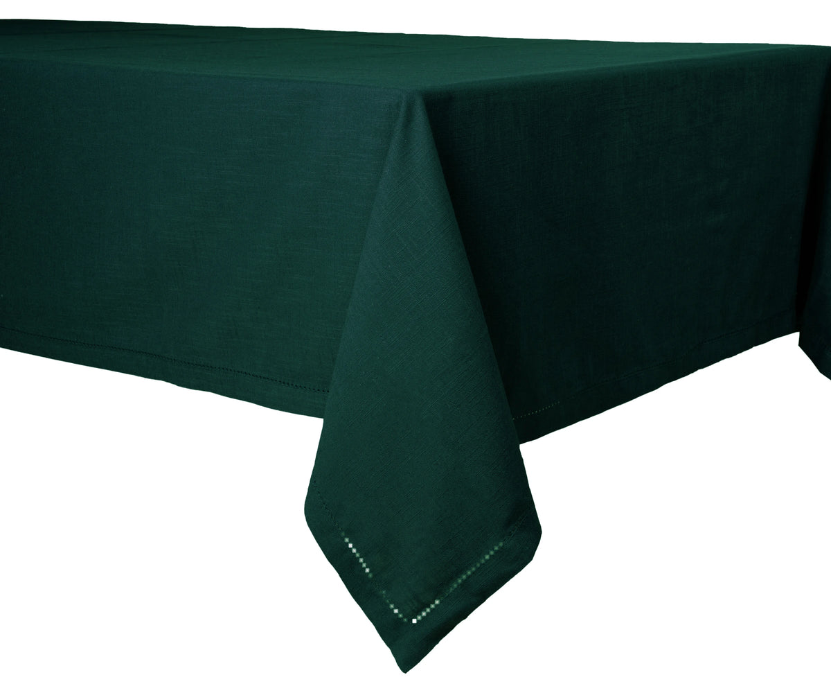 Green cotton hemstitched rectangle tablecloth on a dining table. Green cotton hemstitched rectangle tablecloth on a dining table.