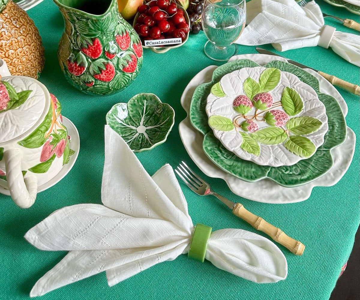 Beautifully folded ivory napkins placed alongside vintage tableware, adding a touch of elegance to the dining experience. Beautifully folded ivory napkins placed alongside vintage tableware, adding a touch of elegance to the dining experience.