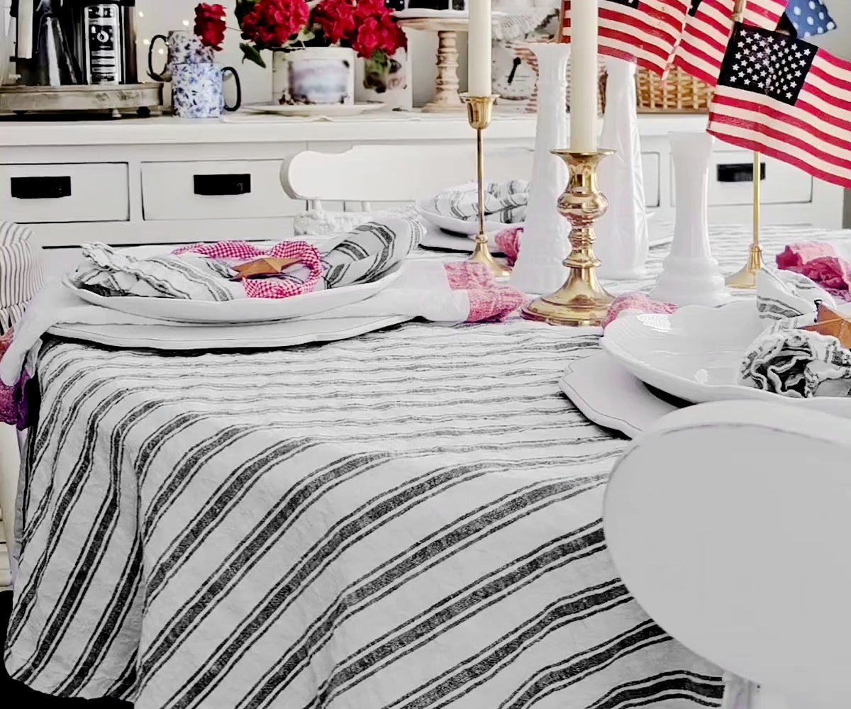 Elegant dining table with a striped linen tablecloth.