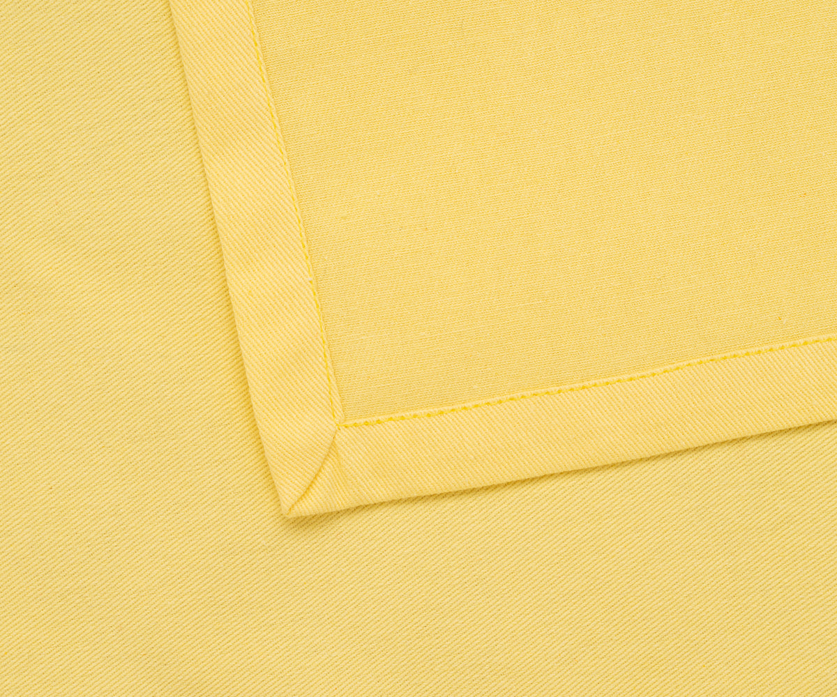 Reusable lemon yellow cloth napkins styled with a neutral table runner. Reusable lemon yellow cloth napkins styled with a neutral table runner.