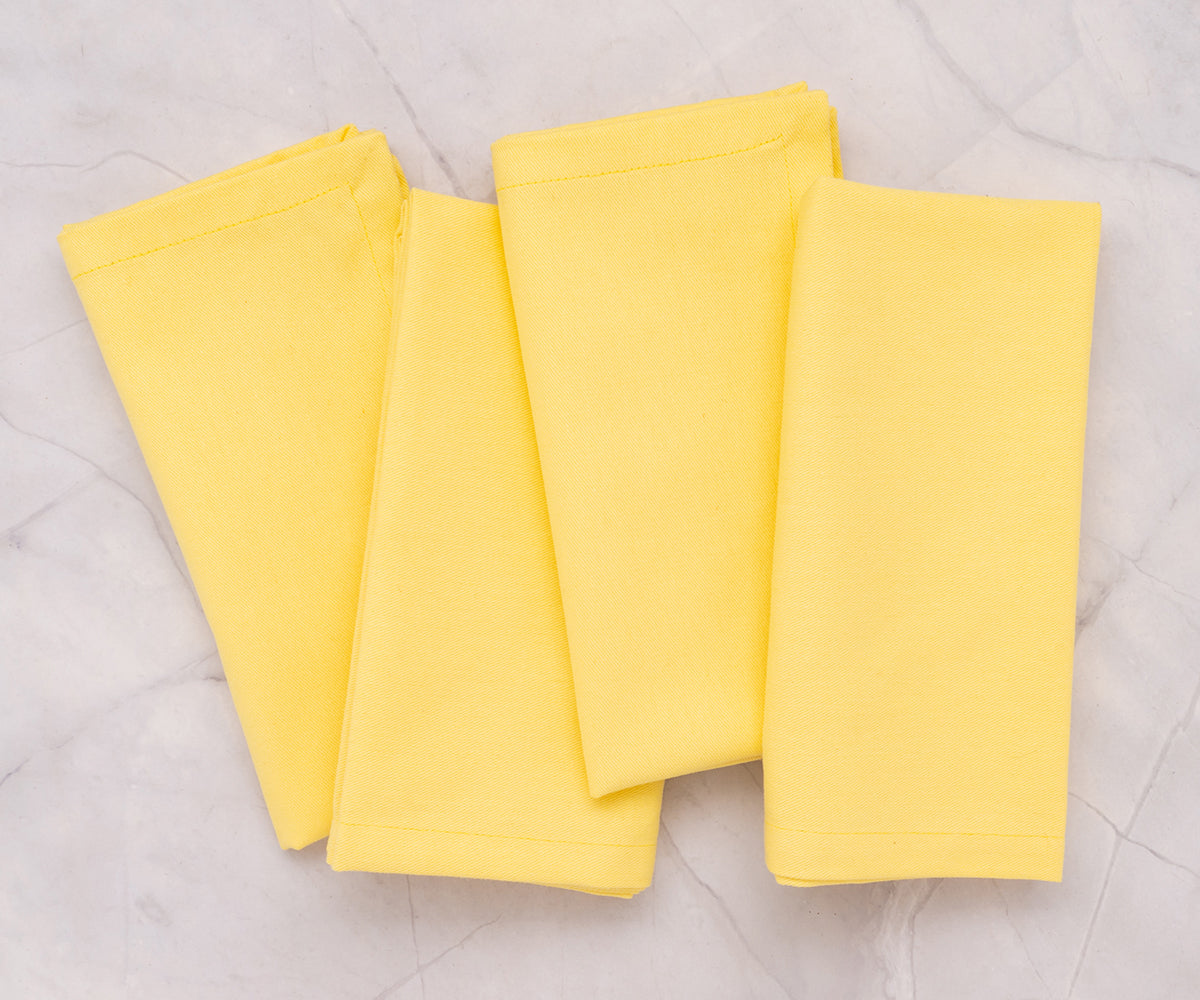 100% cotton lemon yellow napkins stacked and ready for dining use. 100% cotton lemon yellow napkins stacked and ready for dining use.
