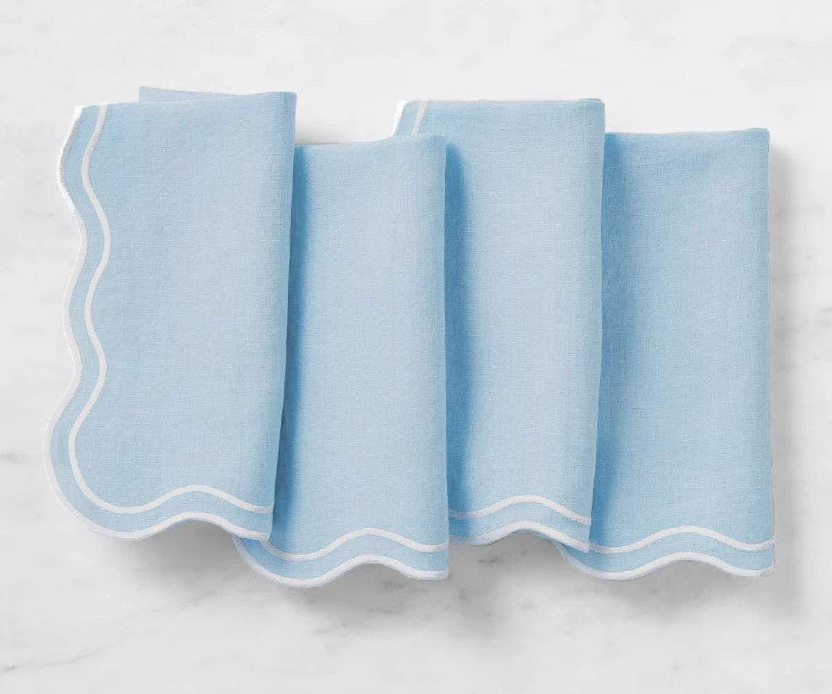 Light blue cotton napkins with scalloped edges arranged on a dinner table
 Light blue cotton napkins with scalloped edges arranged on a dinner table