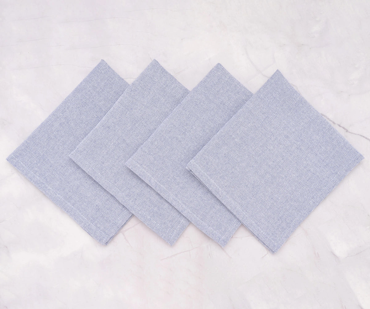 Set of light blue cloth napkins arranged elegantly for a casual dinner setting. Set of light blue cloth napkins arranged elegantly for a casual dinner setting.