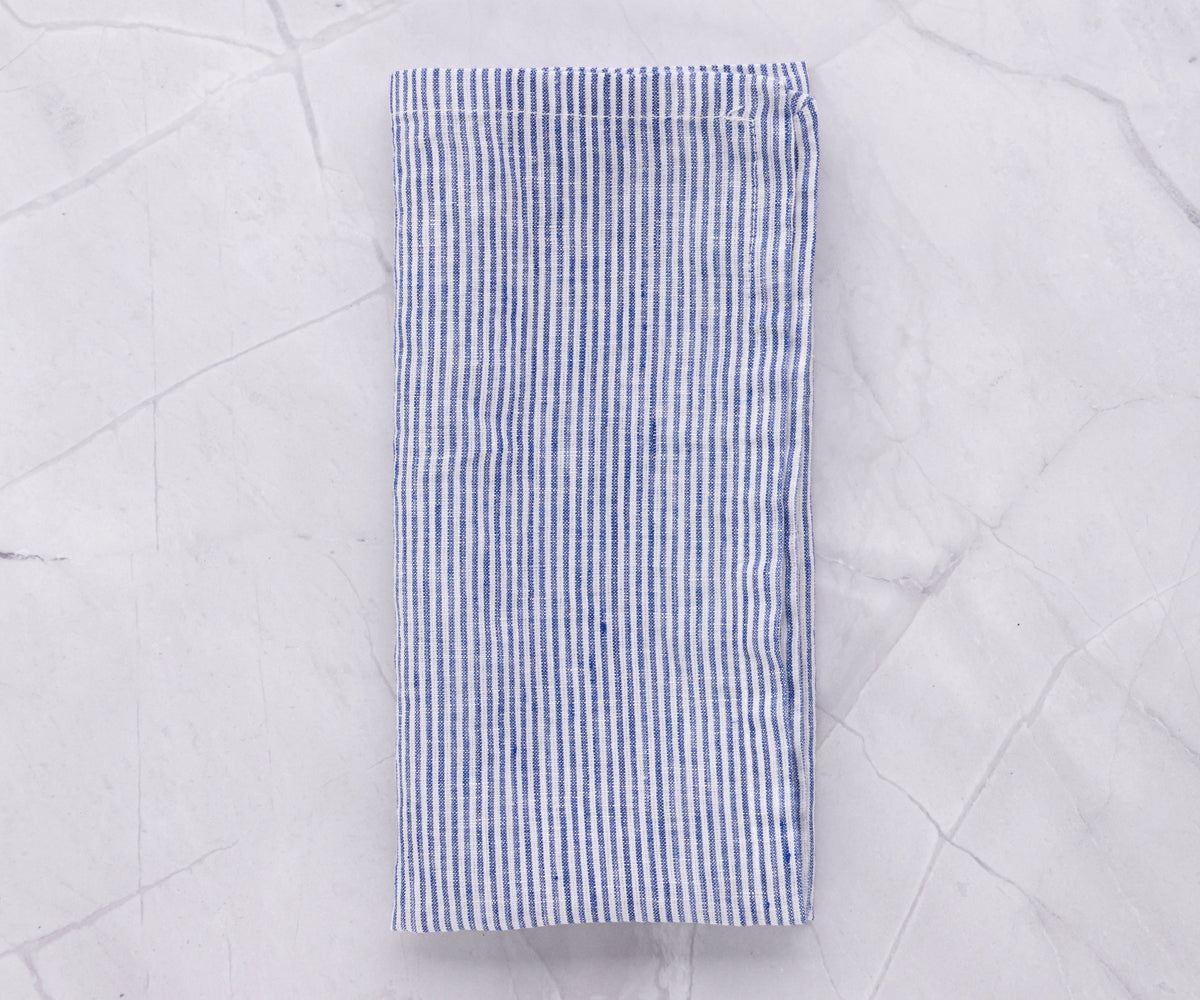 Blue and white linen striped napkin laid out on a marble background Blue and white linen striped napkin laid out on a marble background
