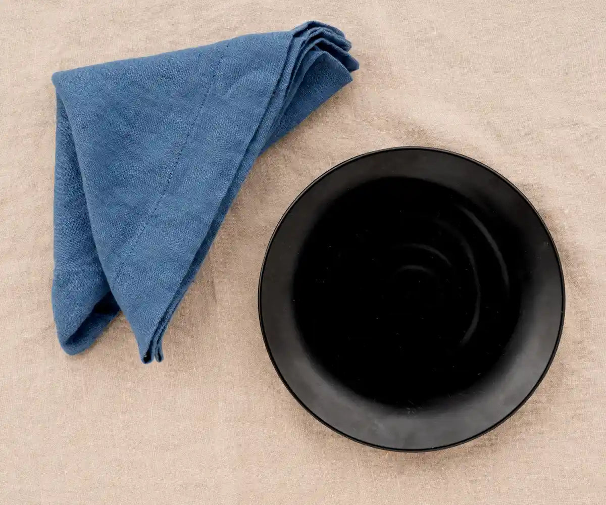Vintage blue linen dinner napkin folded neatly for a classic table setting. Vintage blue linen dinner napkin folded neatly for a classic table setting.