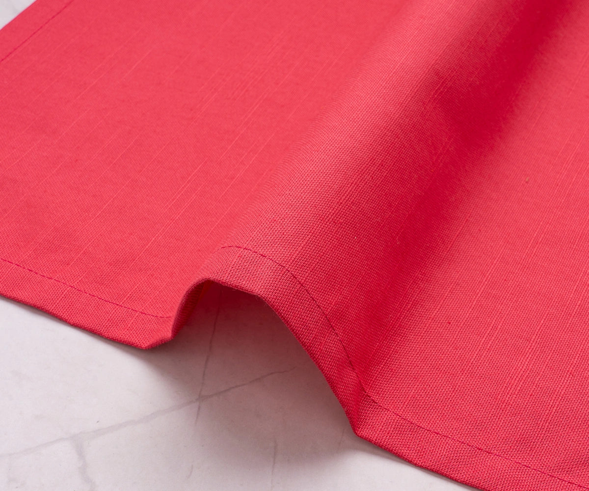 Soft maroon fabric napkin paired with gold cutlery and neutral dinnerware. Soft maroon fabric napkin paired with gold cutlery and neutral dinnerware.