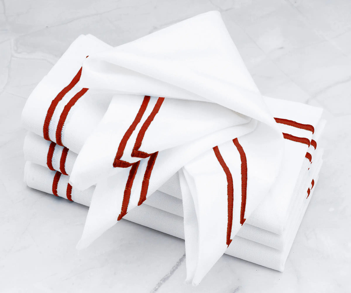 Luxurious linen napkins showcasing a double line of magenta embroidery. Luxurious linen napkins showcasing a double line of magenta embroidery.