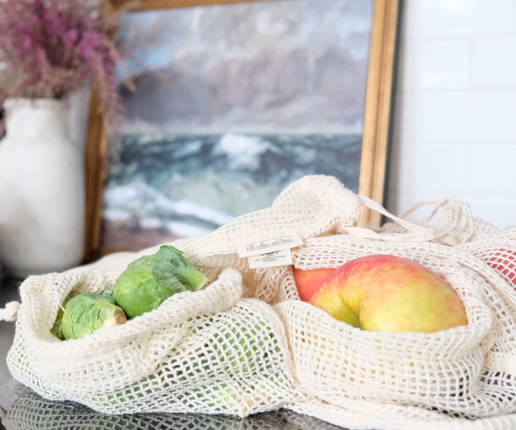 Reusable mesh produce bag with oranges on a kitchen table beside a houseplant Reusable mesh produce bag with oranges on a kitchen table beside a houseplant