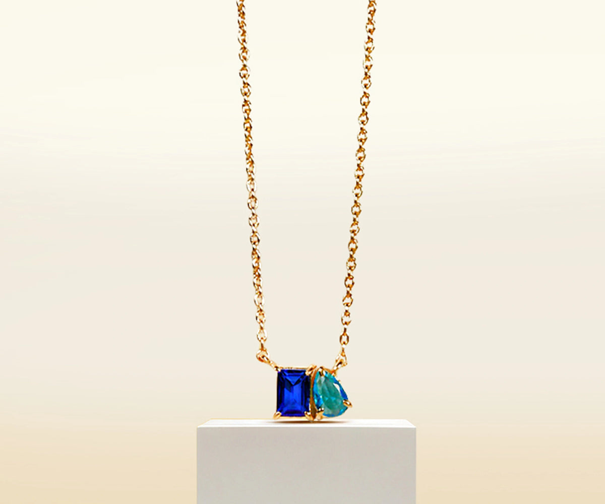 Blue sapphire and topaz pendant on gold chain necklace. Blue sapphire and topaz pendant on gold chain necklace.