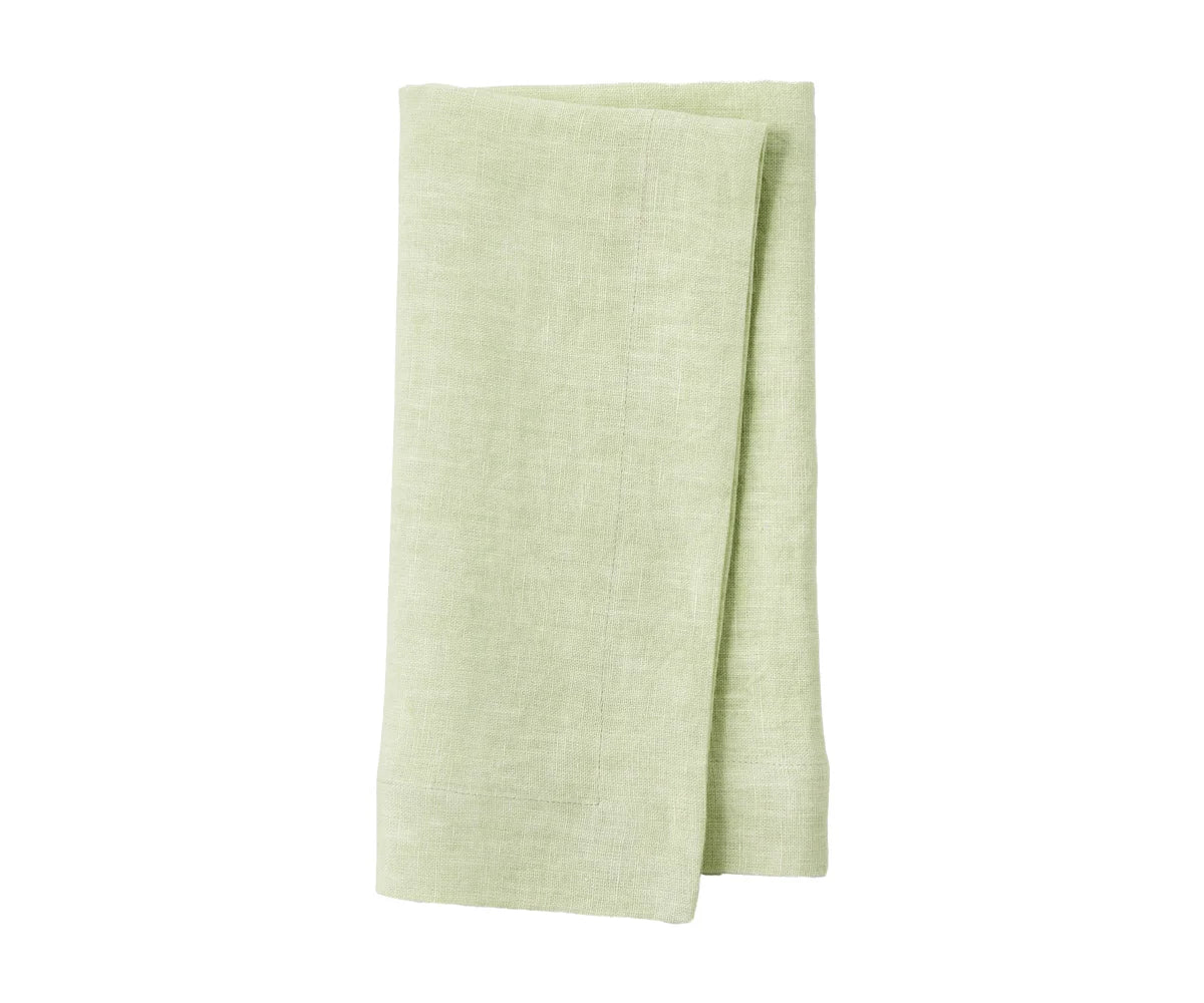 Soft linen napkins stacked on a wooden dining table Soft linen napkins stacked on a wooden dining table