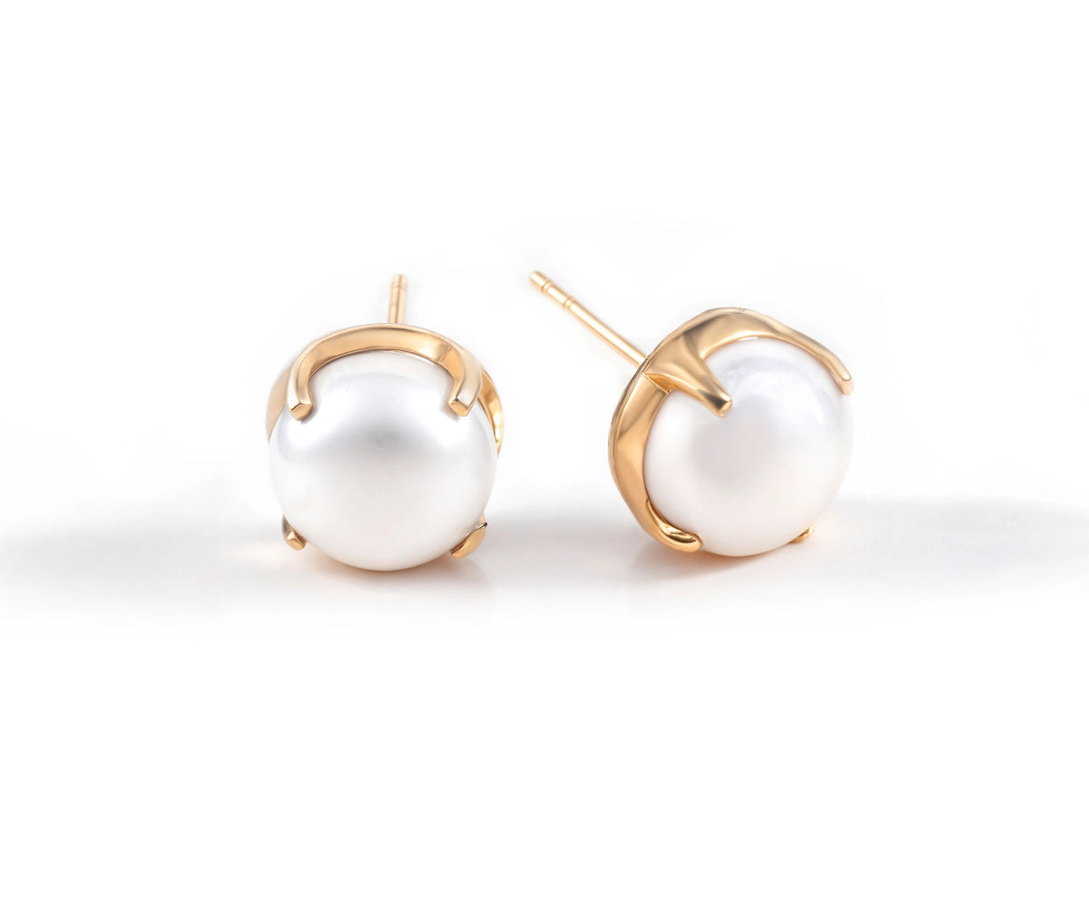 Beautiful pearl stud earrings with yellow gold-plated brass and a timeless design. Beautiful pearl stud earrings with yellow gold-plated brass and a timeless design.