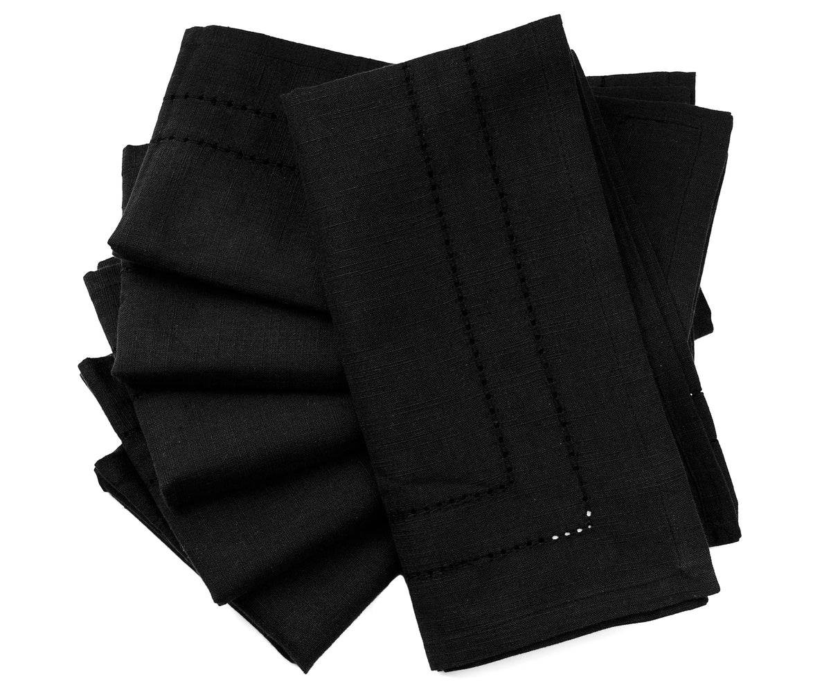 Black napkins arranged on a dinner table, offering a sleek and modern look for an upscale meal. Black napkins arranged on a dinner table, offering a sleek and modern look for an upscale meal.