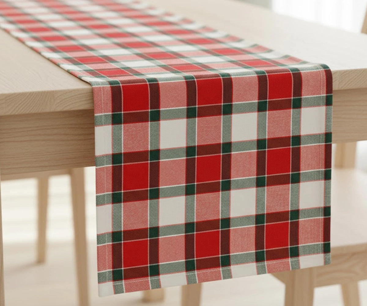 Red, black, and white buffalo plaid cotton table runner adding rustic farmhouse and festive charm to a dining table setting. Red, black, and white buffalo plaid cotton table runner adding rustic farmhouse and festive charm to a dining table setting.