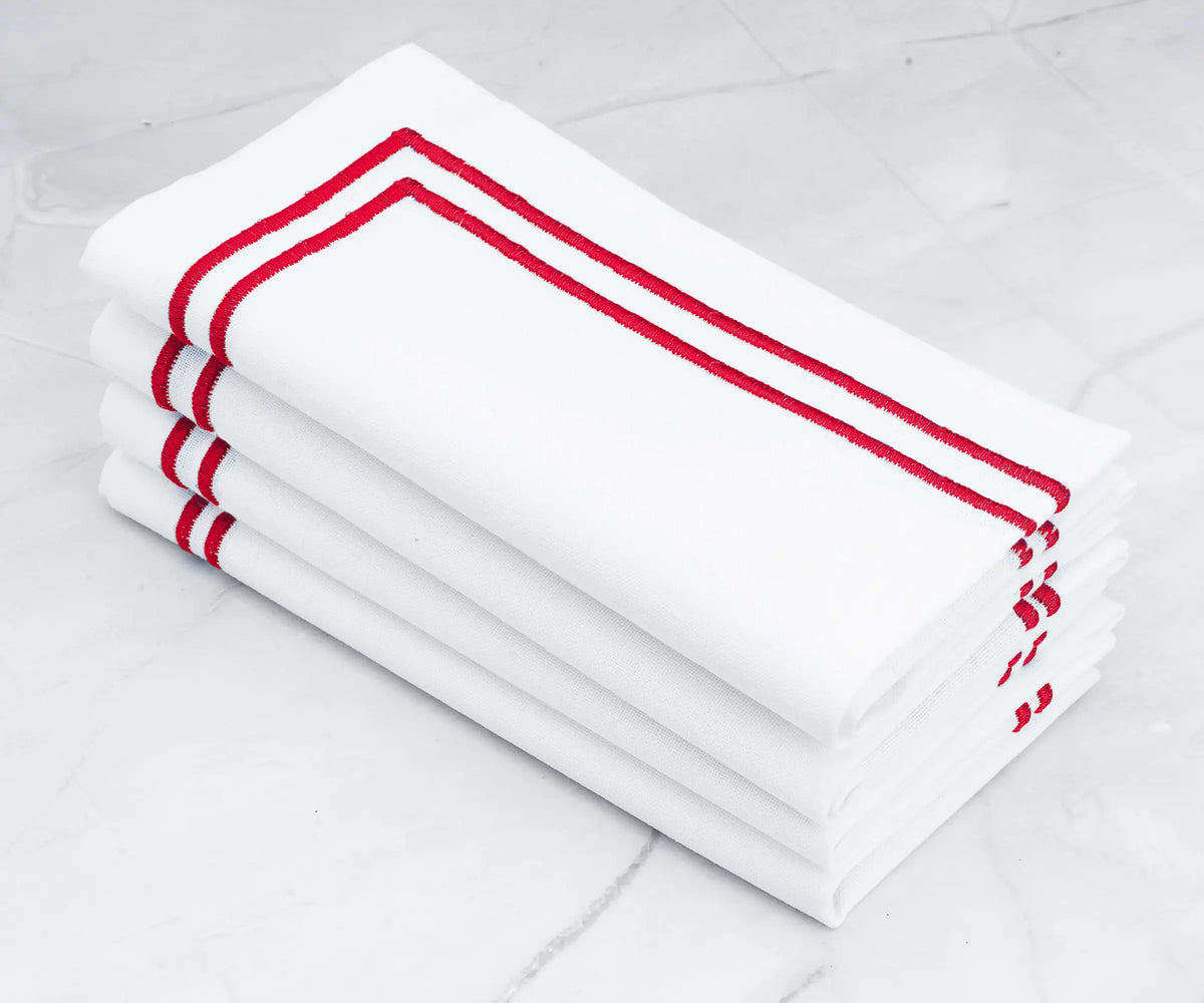 Crisp white napkins with a bold double line of red embroidery. Crisp white napkins with a bold double line of red embroidery.