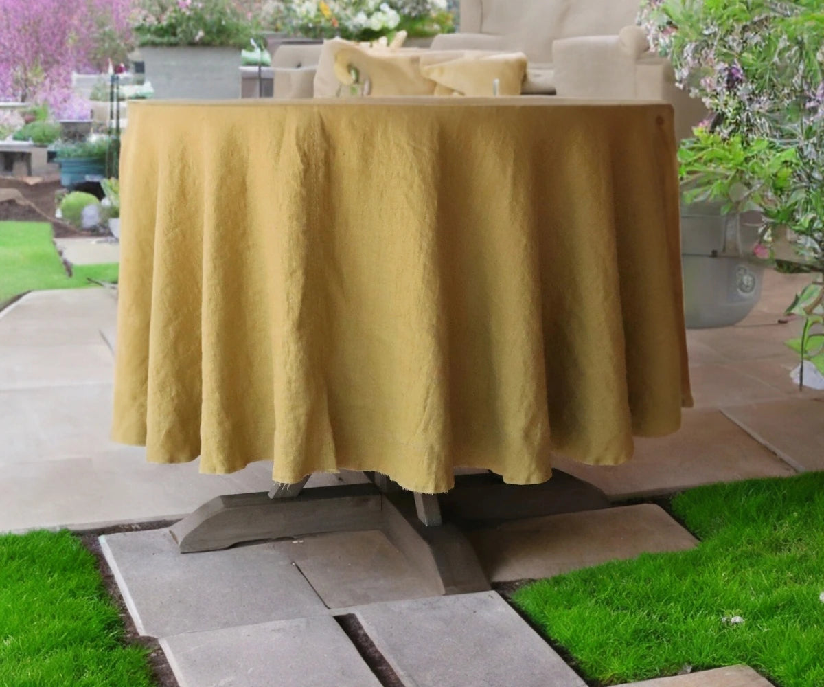 A red linen round tablecloth on a table outdoors, with chairs around it and plants in the background. A red linen round tablecloth on a table outdoors, with chairs around it and plants in the background.