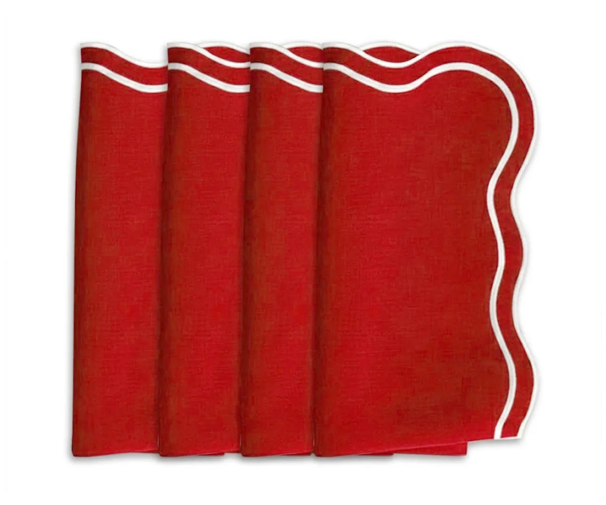 Folded red scalloped cotton napkins on a wooden dining table, ready for a festive meal. Folded red scalloped cotton napkins on a wooden dining table, ready for a festive meal.