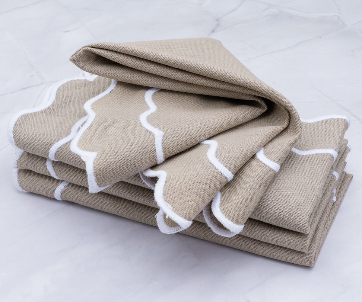 Luxurious beige scallop napkins enhancing a sophisticated table arrangement Luxurious beige scallop napkins enhancing a sophisticated table arrangement