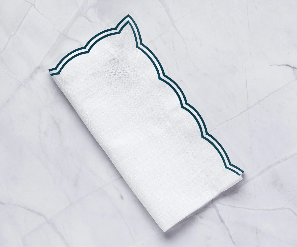 Set of green cotton scalloped napkins styled for seasonal holiday dining Set of green cotton scalloped napkins styled for seasonal holiday dining