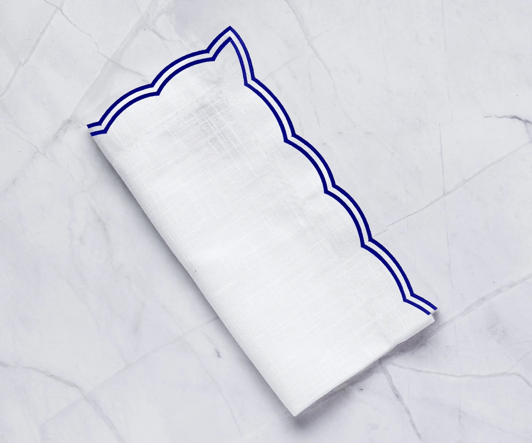 Elegant royal blue dinner napkins with a soft scalloped edge design Elegant royal blue dinner napkins with a soft scalloped edge design