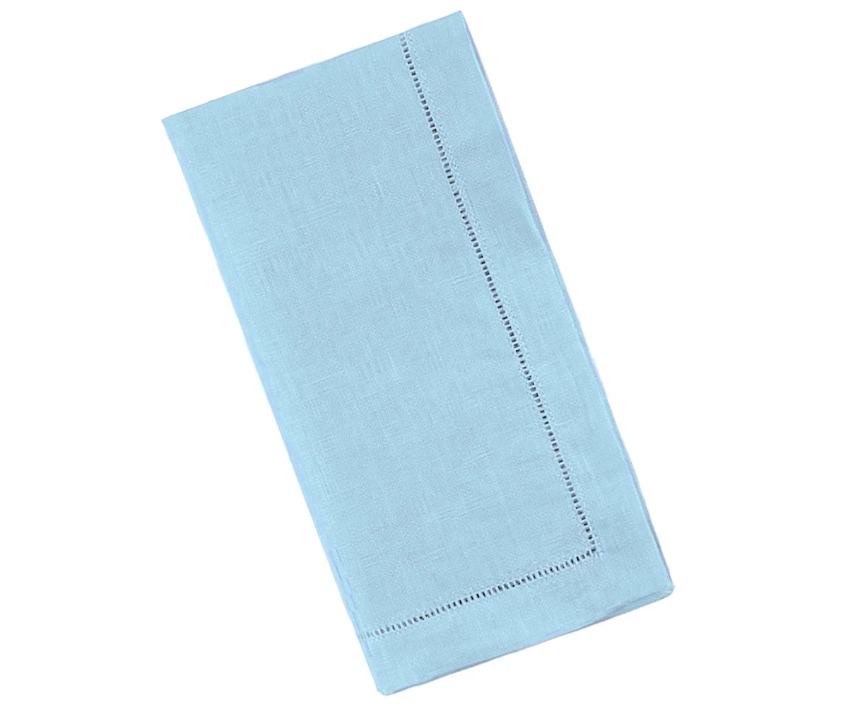 Stack of neatly folded sky blue linen napkins with hemstitched borders on a rustic wooden table Stack of neatly folded sky blue linen napkins with hemstitched borders on a rustic wooden table
