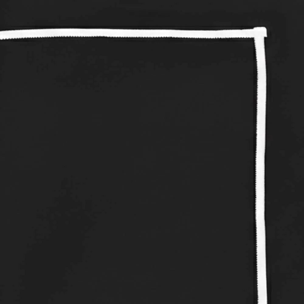 Black embroidered tablecloth with white stitching styled with dinner napkins on rectangular table Black embroidered tablecloth with white stitching styled with dinner napkins on rectangular table