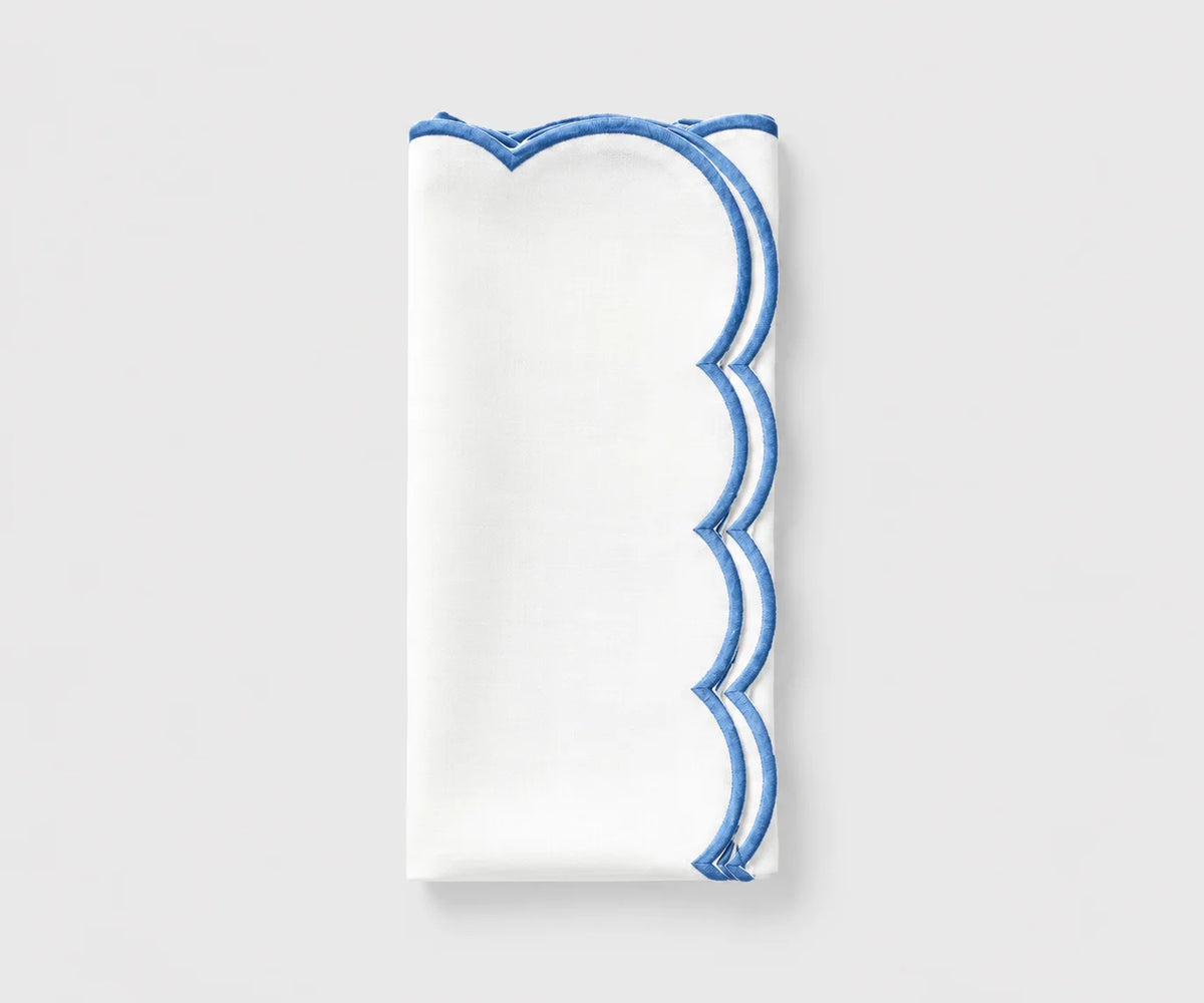 White and blue scalloped cloth napkin folded on a white background White and blue scalloped cloth napkin folded on a white background