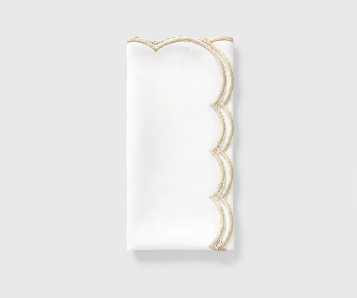 White and ivory scalloped cloth napkin folded on a white background White and ivory scalloped cloth napkin folded on a white background
