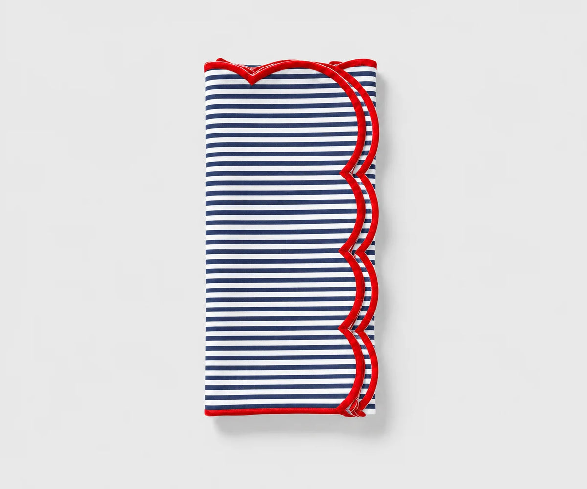Navy blue and white striped cloth napkin with red scalloped trim folded on a white background Navy blue and white striped cloth napkin with red scalloped trim folded on a white background