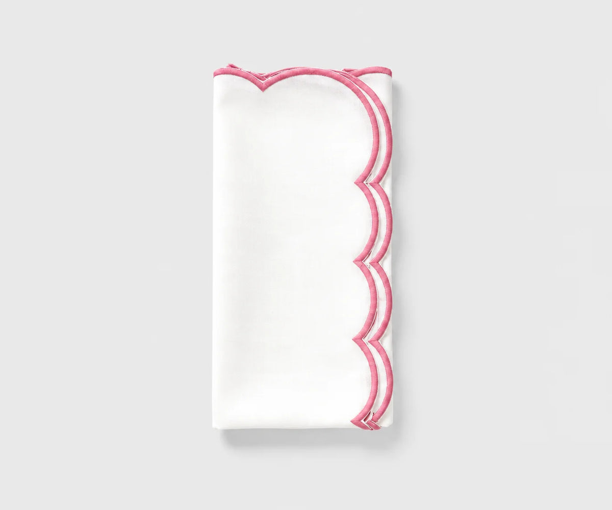 White and pink scalloped cloth napkin folded on a white background White and pink scalloped cloth napkin folded on a white background