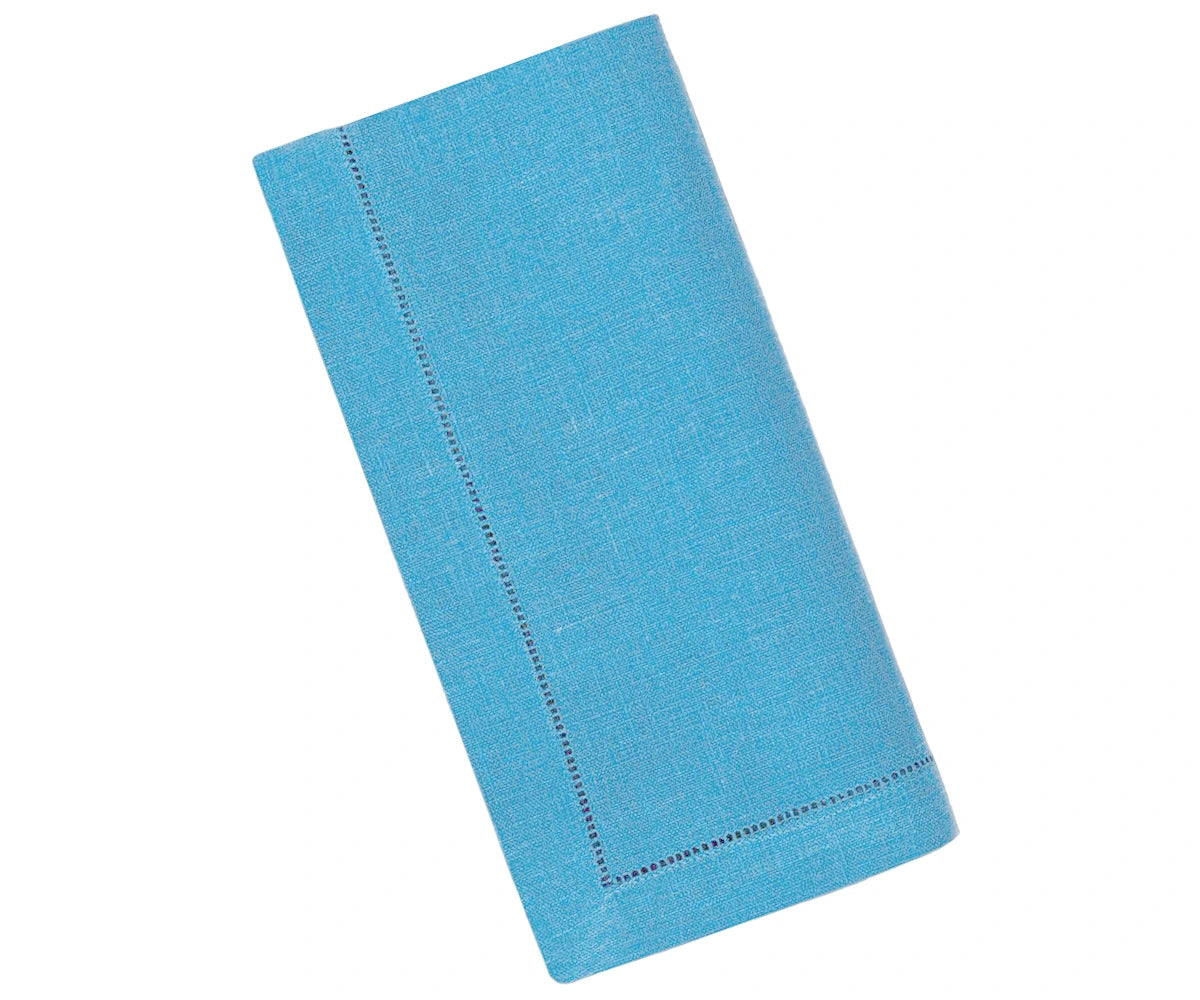 Teal linen napkins with hemstitch detailing neatly folded on a dining table Teal linen napkins with hemstitch detailing neatly folded on a dining table
